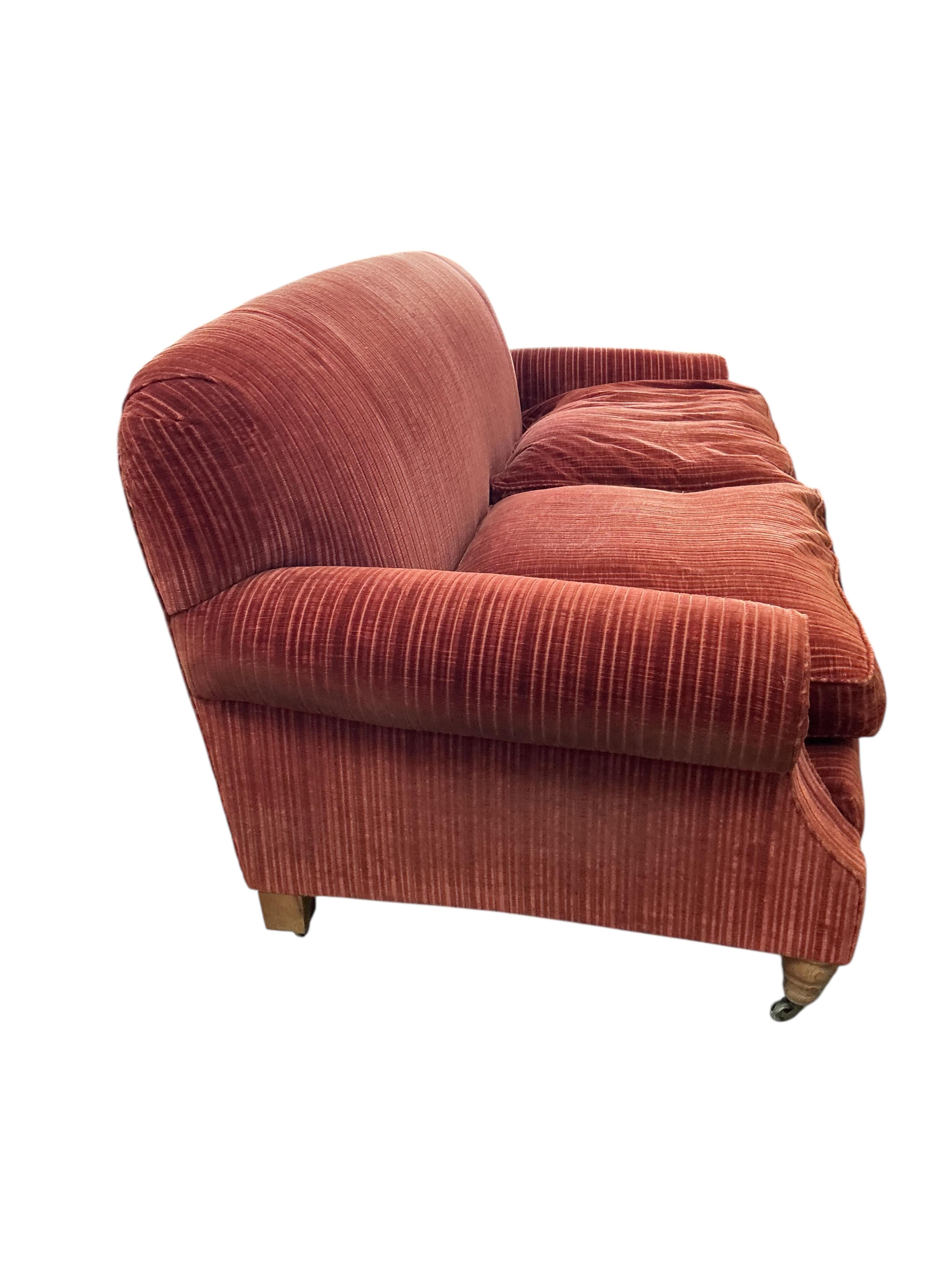 A modern Howard style upholstered two seater settee, width 206cm, depth 92cm, height 84cm, Provenance: The late Kenneth Turner (1936-2025), celebrity florist, designer and perfume retailer, he received the Royal Warrant